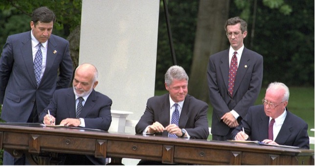 Jordans kong Hussein og Israels premierminister Yitzhak Rabin underskriver fredsaftalen i oktober 1994. I midten USA's præsident Bill Clinton